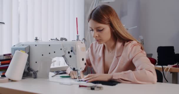 A woman, a clothing designer, cuts scissors in the workshop. — Stock Video