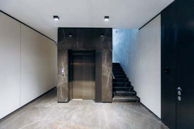 Experience a sleek elevator area that features elegant stairs, modern architectural elements, and contemporary decor