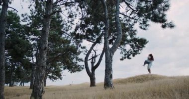 A loving couple enjoys a joyful moment together in the stunning beauty of nature and tall, enchanting trees