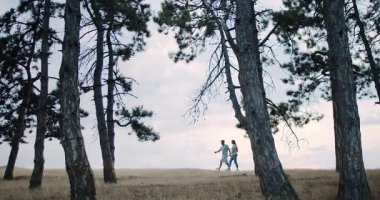 A loving couple walks joyfully handinhand, enjoying every moment in a peaceful and tranquil forest setting