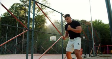 An athlete skillfully showcasing various boxing techniques in a vibrant outdoor urban training environment