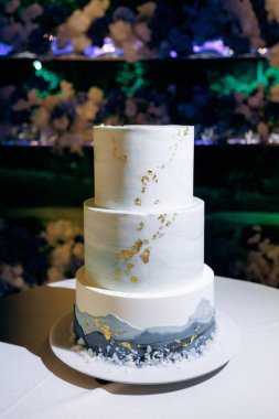 Zarif düğün pastası, üç katlı lüks düğün pastası ince mermer ve pırıl pırıl altın dokunuşlar.