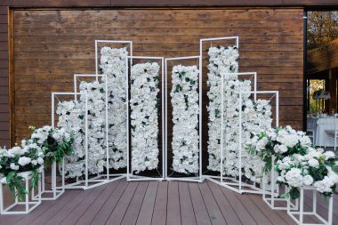 Sıcak ahşap arka plana karşı modern çiçek düzenlemesi, sessiz sonbahar ışıklandırması ve gösterişli şık botanik dekoru.