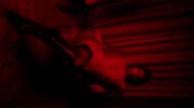 Yatakta RedLit Dansçısı, baştan çıkarıcı pozlar çorap ve saten, koyu gölgeler ve yatay perde,