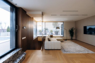 Duvara monte edilmiş televizyon ve düşük profilli kanepe dokulu halı ve doğal halı ile sakin bir eğlence alanı yaratıyor.