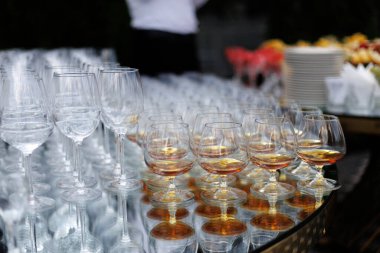 Gözlükler ışıl ışıl parlıyor, kehribar sıvılarıyla dolu zarif bardaklar alacakaranlık sosyal etkinliği için ortam yaratıyor.