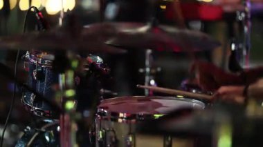 davul takımı dövmeli kollarla yakın çekim, saldırgan tuzaklar ve çarpan ziller, parlak sahne ışıkları, ham güç ve sürüş