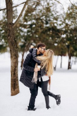 Karlı öpücük için erkek kaldırma, neşeli hareketler ve düşüşle eğlenceli park yürüyüşü sırasında spontane evlenme teklif sahnesi
