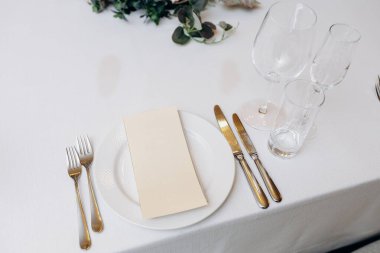 Gelişmiş fildişi ve altın masa dekorasyonu teması, kristal ve parlak çatal bıçaklarla yenilenmiş nötr damak.