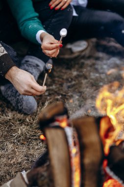 Parlayan közler ve kahkahalarla gece vakti toplanan kampçılar, gece boyunca yanan ateşin üzerinde lokum kızartıyorlar.