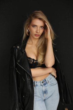 Zarif özgüven portresi, beyaz kadın saçlarını samimi olarak düzeltirken modaya uygun giyiniyor.