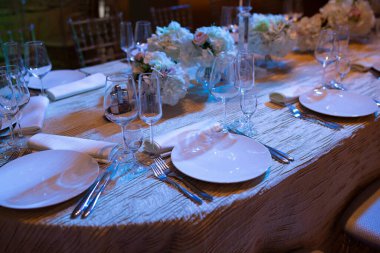 Dekoratif dekoratif kumaşlar ve çiçeklerle donatılmış, sofistike çiçeklerle dolu özel kabul alanı.