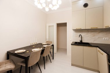 Özel yemek köşesi, sofra sofra takımları, mum ışığı bej dolaplar ve akışkan kumaşlar.