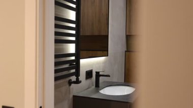 Lavabo, siyah musluk ve havlu radyatörü, stilistik ürün görüntüleme dokusu, seramik leğen, sıcak ışıklandırma