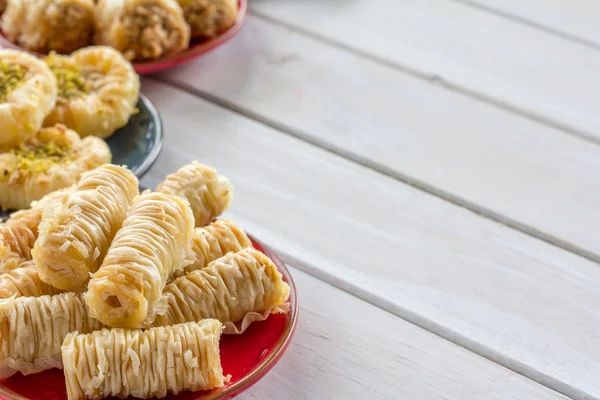 Verscheidenheid van Baklava op platen op tafel — Stockfoto