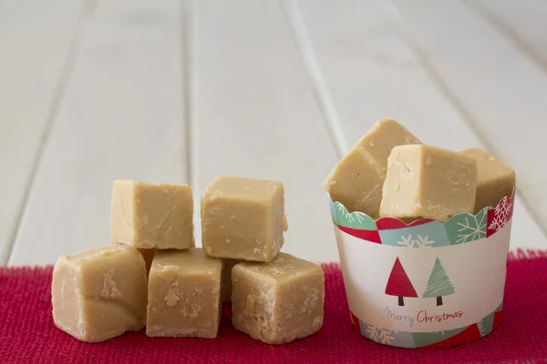 Beker van karamel Fudge kerstcadeau met stapel aan kant — Stockfoto