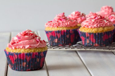 Çörekler ve pembe Frosting bir raf pişirme üzerinde kapat
