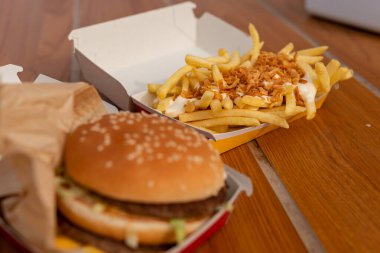 Soslu kızarmış patates, mayonez ve büyük lezzetli bir çizburger, gerçek yemek pornosu.