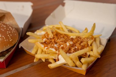 Soslu kızarmış patates, mayonez ve büyük lezzetli bir çizburger, gerçek yemek pornosu.