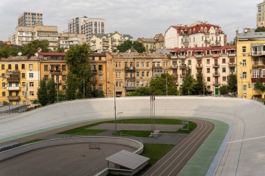 Kyiv (Kiev), Ukrayna - 10 Ekim 2020: Devrimden önce farklı mimarisi olan eski ve eski yerleşim öncesi binaların yakınındaki stadyum bisiklet pisti