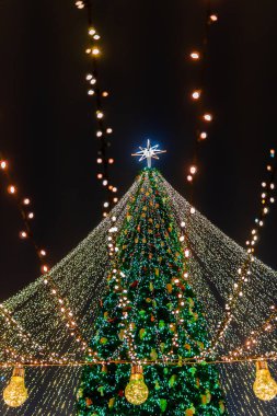 Güzel dekore edilmiş Noel ağacı bir sürü küçük ışık ve yeni yılın sembolleriyle