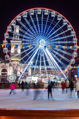 Kyiv (Kiev), Ukrayna - 6 Ocak 2021: Birçok insan ve çocuk büyük bir dönme dolabın yanında buz pateni yapmaya gider