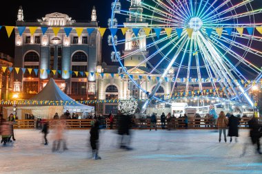 Kyiv (Kiev), Ukrayna - 6 Ocak 2021: Birçok insan ve çocuk büyük bir dönme dolabın yanında buz pateni yapmaya gider