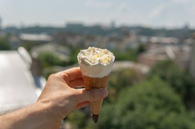 Sıcak ve güneşli bir yaz gününde elinde beyaz çikolatayla tatlı tatlı dondurmalı mısır.