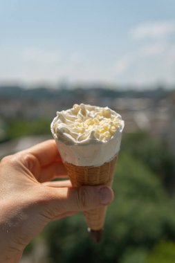 Sıcak ve güneşli bir yaz gününde elinde beyaz çikolatayla tatlı tatlı dondurmalı mısır.