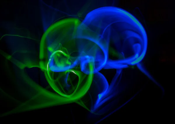 Siyah zemin üzerine yeşil ve mavi hareket ışınları soyut. Bir gece disko parti için arka plan.