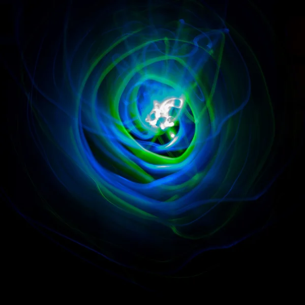 Abstrakte grüne und blaue Bewegungsstrahlen auf schwarzem Hintergrund. Hintergrund für eine nächtliche Disco-Party. — Stockfoto