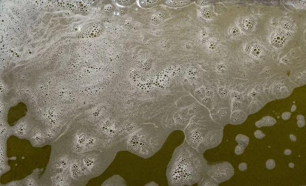 Fondo abstracto con espuma blanca en una superficie de color fuera de foco. Enfoque selectivo en la limpieza de espuma. — Foto de Stock