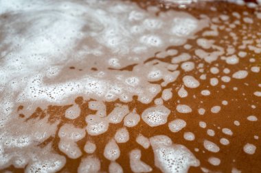 Beyaz köpüklü soyut arkaplan, odak dışı renkli bir yüzey. Temizlik köpüğüne odaklan