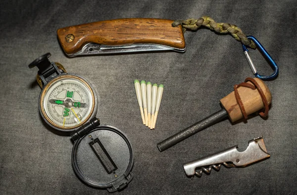 EDC。ウェアラブルサバイバルキット。ナイフ、コンパス、狩猟の折り曲げは、フリントと一致します。森の中で一晩のためのツール。遠征の道具 — ストック写真