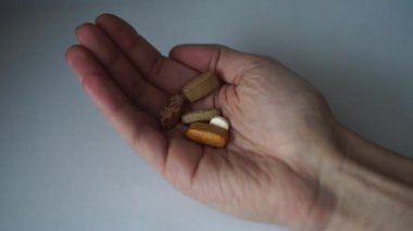 Farklı renk ve boylarda tabletler avucunuzun içine düşer. Eczane tedavisi konsepti. Ağrı kesici, antibiyotik, kas dehidrasyon hapı, omurga sübvansiyonu için avuç içinde kalsiyum tableti..