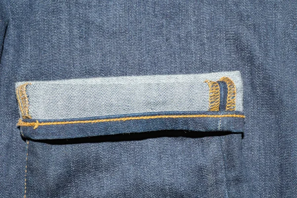 The rolled-up edge of the denim pants. Jeans on the wrong side — Stock Photo, Image