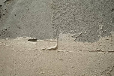 Sert bir beton yüzeyin dokusu. Duvarda gri ve beyaz alçı.