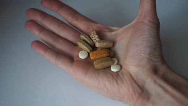 Különböző formájú, méretű és színű tabletták a tenyerében — Stock videók