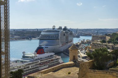 Modern yolcu gemisi MSC World Europa 'nın yer aldığı Valletta, Malta' daki liman sahnesi tarihi bir taş kalenin yanındaki başka bir gemiye kenetlendi.