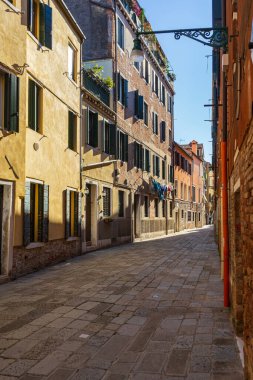 İtalya, Venedik 'te dar bir sokak, tarihi binaların arasında kirli çamaşırlar asılı. Şehirde günlük hayat sahnesi.