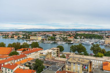 Hırvatistan 'ın Zadar kenti - 01.10.2025: Hırvatistan' ın Adriyatik kıyısındaki tarihi şehir Zadar 'ın havadan görünüşü. Sahne kırmızı kiremitli çatılar, yat ve tekneli marina gösteriyor.