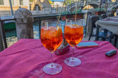 Venedik, İtalya 'da kanal manzaralı bir restoranda iki bardak Aperol Spritz kokteyli.