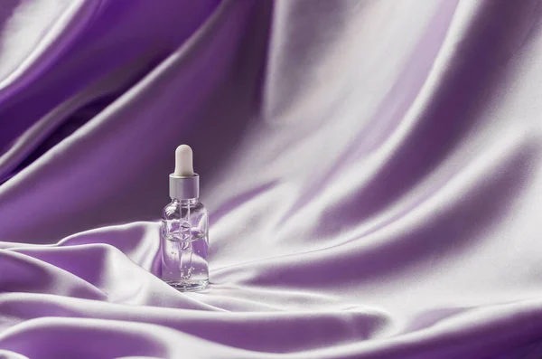Serum Twarzy Liliowym Jedwabnym Składanym Tle Tkaniny Luksusowy Kosmetyczny Produkt — Zdjęcie stockowe