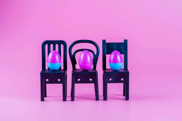 Renkli Plastik Paskalya Yumurtaları Pembe Arka Planda Küçük Sandalyeler Üzerinde — Stok fotoğraf
