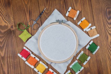 Genişletilmiş tuvalle çapraz dikiş, tasarımcı için boş, ahşap bir arka planda.