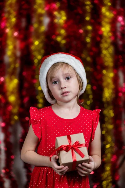 Roztomilé Holčička Santa Klobouku Drží Vánoční Dárek Usmívá Kameru — Stock fotografie