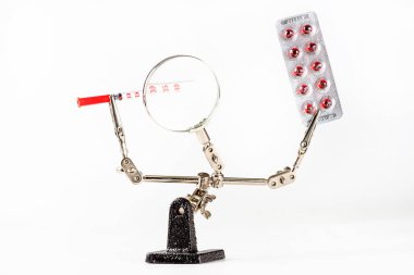 Üçüncü el tablet ve şırınga tutan soyut ilaç geçmişi