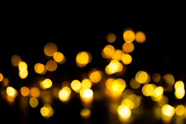 Bokeh brilhante dourado no fundo preto. Dia dos namorados ou fundo de Natal. — Fotografia de Stock