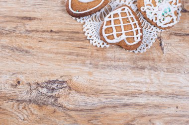 Ev yapımı kalp şeklinde kurabiyeler, üzerine beyaz krema serpilmiş.