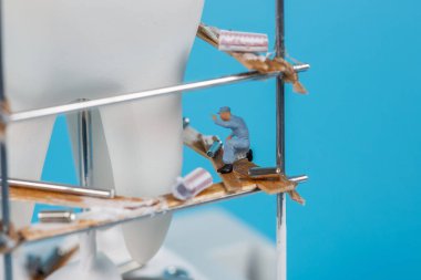 Moskova, Rusya - 9. Matra 2021: Bir insan dişi modeli ve etrafında küçük figürlerin yer aldığı bir sanat eseri. Diş yapılandırma, diş konsepti.